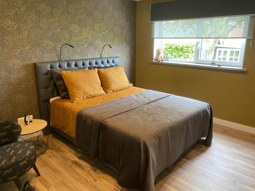 Simonshaven的住宿－BenB VoornePutten，一间卧室设有一张床、一个窗口和一把椅子