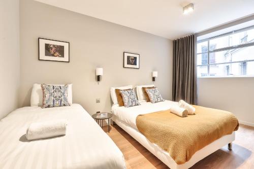 - 2 lits dans une chambre avec fenêtre dans l'établissement 123 - Urban Luxury Flat in Montorgueil, à Paris