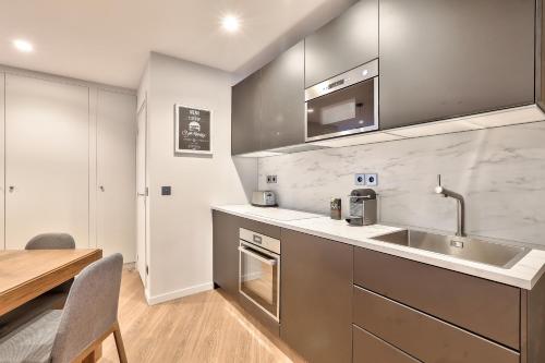 - une cuisine avec un évier et une table en bois dans l'établissement 123 - Urban Luxury Flat in Montorgueil, à Paris