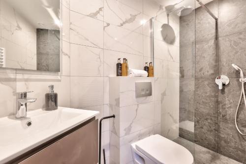 La salle de bains blanche est pourvue d'un lavabo et de toilettes. dans l'établissement 123 - Urban Luxury Flat in Montorgueil, à Paris