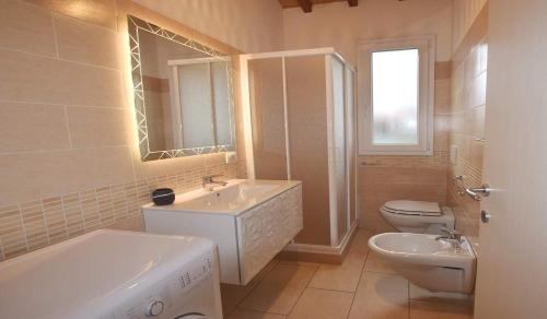 ein weißes Bad mit einem Waschbecken und einem WC in der Unterkunft VILLETTA LA ZANCA in Zanca