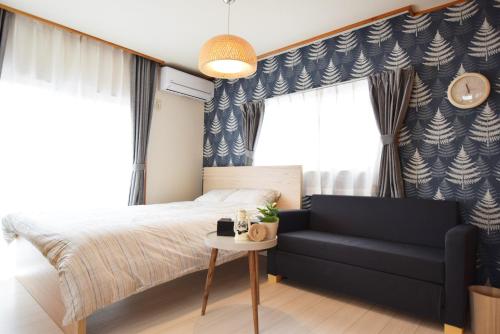 a bedroom with a bed and a couch at Sasatsuka Fleur Tachibana Hotel Apartment in Tokyo