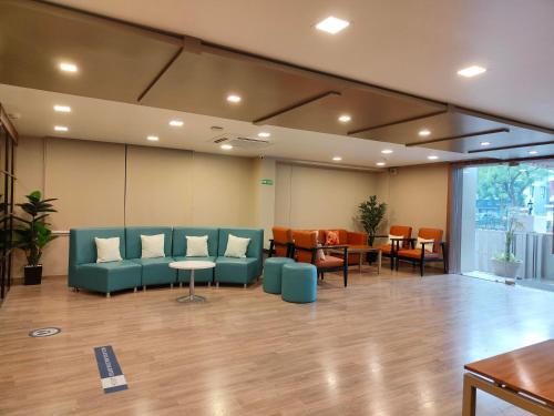 a waiting room with a couch and tables and chairs at Kanak Beacon Hotel - Ashram Road Ahmedabad in Ahmedabad
