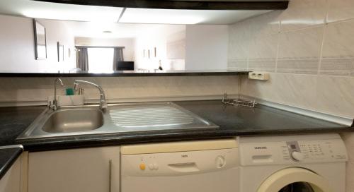 una cocina con fregadero y lavadora en Palmeira Gale - WIFI - Pool - Lux - BY BEDZY, en Albufeira