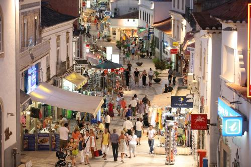 a crowd of people walking through a shopping street at The Navigator - Solaqua in Albufeira