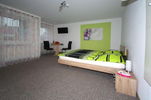 Schlafzimmer mit einem Bett und einem Schreibtisch mit Stühlen in der Unterkunft Ferienwohnung in Kempten am Stadtweiher in Kempten
