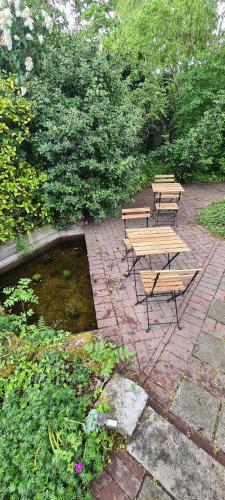 two picnic tables and benches on a brick patio at B&B Willem II in Roermond