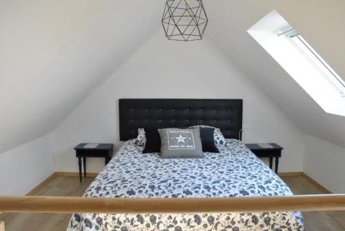 une chambre avec un lit et deux tables de nuit dans l'établissement Cap sur le Phare à Moguériec, à Sibiril