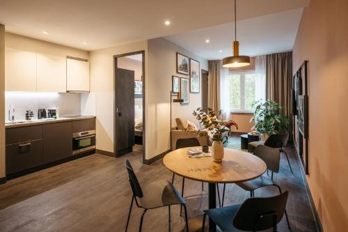 a kitchen with a table, chairs and a refrigerator at YAYS The Hague Willemspark in The Hague