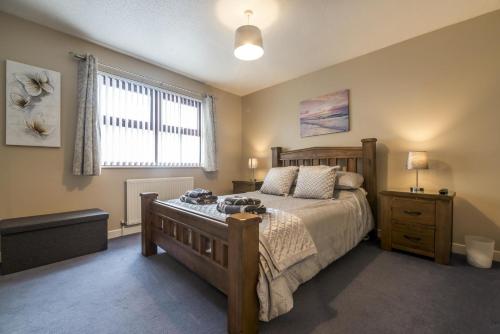 a bedroom with a large bed and a window at Harry's - 2 Bedroom Holiday Home - Tenby in Tenby