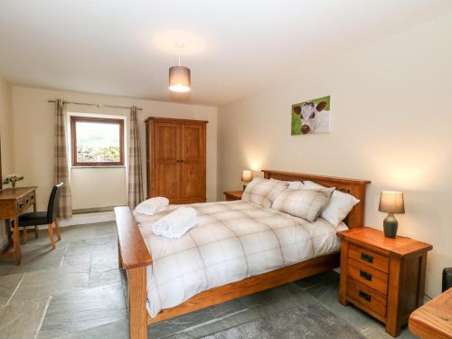 Un dormitorio con una cama y un escritorio y una ventana. en The Haybarn, en Ashbourne