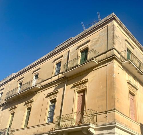 un edificio con balcones y un cielo azul en HABITARE Lecce & Salento en Lecce