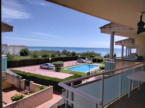 a balcony with a view of a pool and the ocean at Apartamento frente al mar in Les Cases d'Alcanar