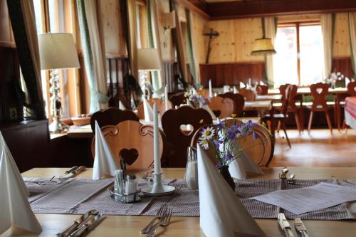 a dining room with a table with chairs and a table set up at Schlosswirt Chalets & Apartments in Großkirchheim