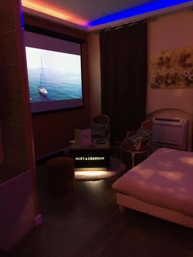 une pièce avec une télévision avec un bateau sur l'écran dans l'établissement chambre avec spa by jordans collection, à Dijon