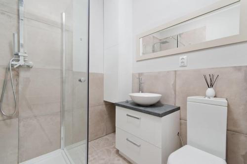 a bathroom with a toilet and a sink and a shower at Central Apartments Ogarna 3 in Gdańsk