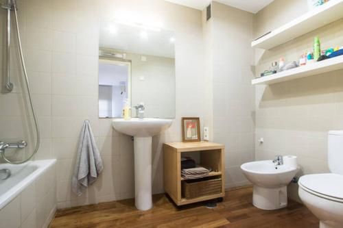 a white bathroom with a sink and a toilet at Apartamento Centro & Chic in Alicante