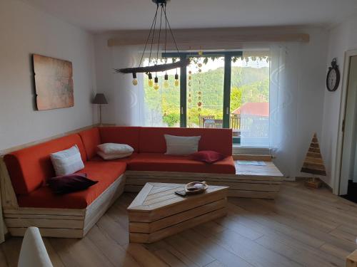 sala de estar con sofá rojo y ventana en Eure Auszeit en Vöhl