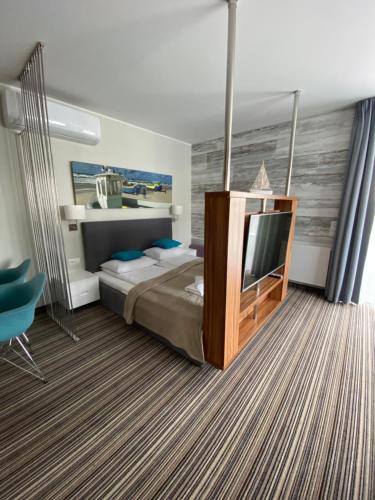 a bedroom with a bed and a flat screen tv at Apartamenty Krynica No.1 in Krynica Morska