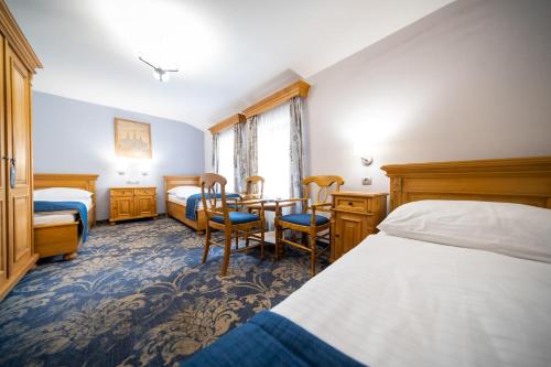 a hotel room with a bed and a table and chairs at Hotel U Kata in Kutná Hora