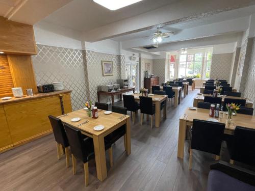 a dining room with wooden tables and chairs at Queens Hotel, Skegness in Skegness