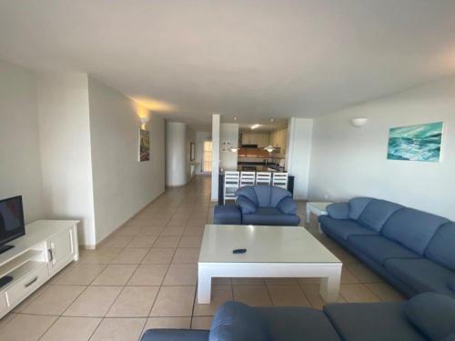a living room with blue couches and a tv at Sorgente 305 in Umdloti
