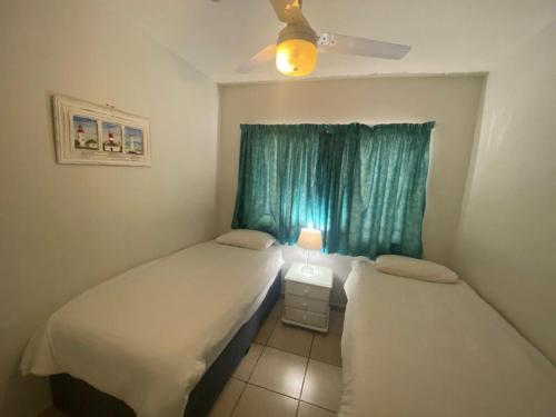 two beds in a small room with a window at Sorgente 305 in Umdloti