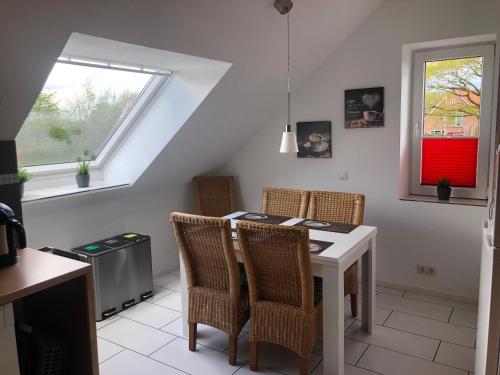 a dining room with a table and chairs and a window at Am Anker in Langballig