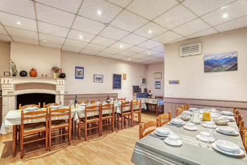une salle à manger avec tables et chaises et une cheminée dans l'établissement Maison spacieuse à Bagnères-de-Luchon près des pistes, idéale., à Luchon