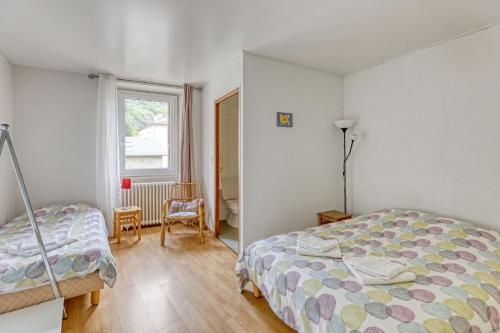 une chambre avec un lit, une chaise et une fenêtre dans l'établissement Maison spacieuse à Bagnères-de-Luchon près des pistes, idéale., à Luchon