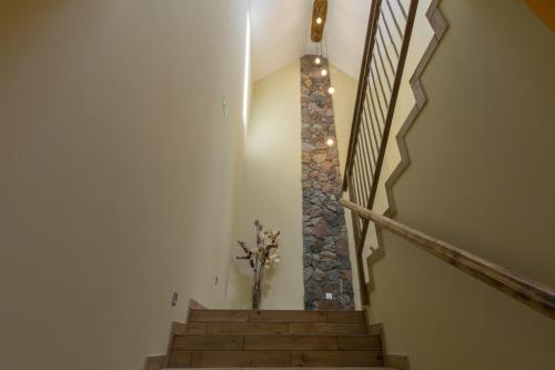 a staircase with a stone wall and a vase of flowers at Pokoje Gościnne Butryny in Butryny