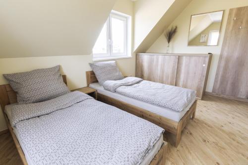a bedroom with two beds and a window at Pokoje Gościnne Butryny in Butryny
