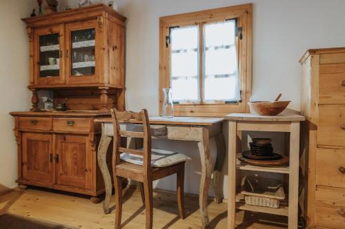 a kitchen with a wooden desk and a wooden chair at Drevenica Traditional Cottage Old Centre in Zuberec