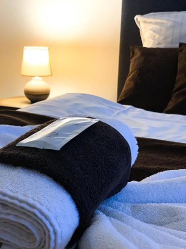 a bedroom with two beds with white towels and a lamp at Aranykorona Hotel in Miskolc