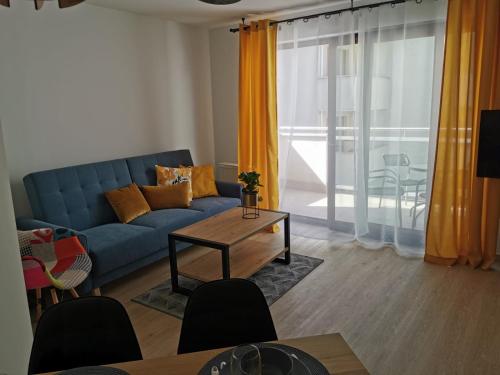 弗瓦迪斯瓦沃沃的住宿－Apartament Zofia 2 Przy Plaży，客厅配有蓝色的沙发和桌子