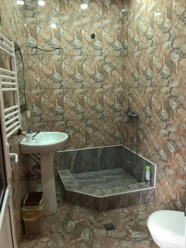 a bathroom with a sink and a bath tub at Hotel Texel in Borjomi