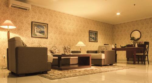 a living room with a couch and chairs and a table at Travellers Suites Serviced Apartments in Medan