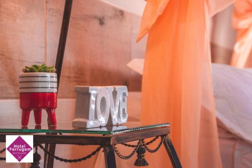 a glass table with a candle and a potted plant at Hotel Ferrugem Eco Village in Garopaba