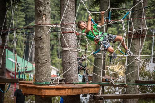 a young boy is climbing on a rope park at Rila Hotel Borovets in Borovets