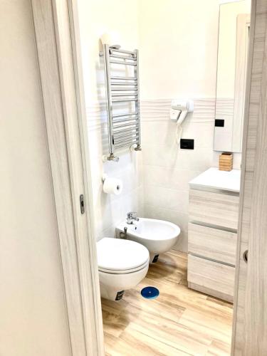 a white bathroom with a toilet and a sink at Pigneto Square Home in Rome