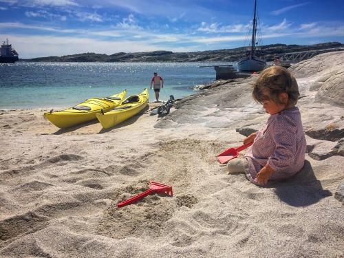 a little girl playing in the sand on the beach at Panorama Hotell & Resort in Steinsland