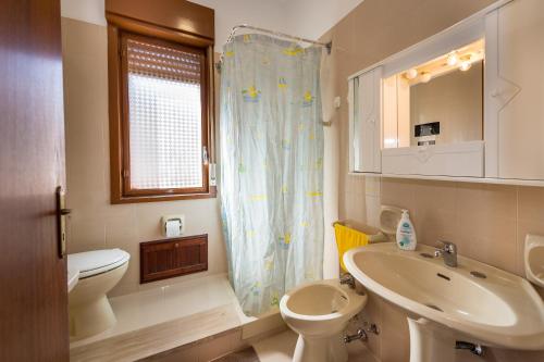 a bathroom with a sink and a toilet and a window at Case Maria in Castellammare del Golfo