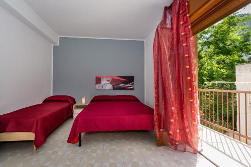 a bedroom with two beds and a balcony at Case Maria in Castellammare del Golfo