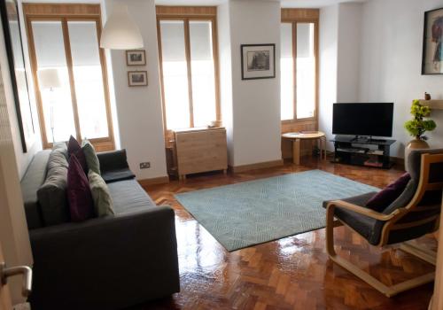 a living room with a couch and a television at The David Hume Residence in Edinburgh