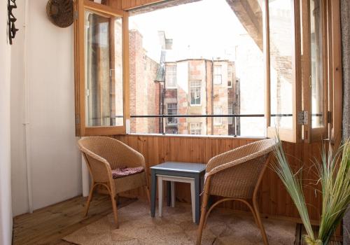 a balcony with two chairs and a table and a window at The David Hume Residence in Edinburgh
