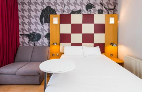 a bedroom with a bed and a couch at ibis Styles Haydock in Haydock