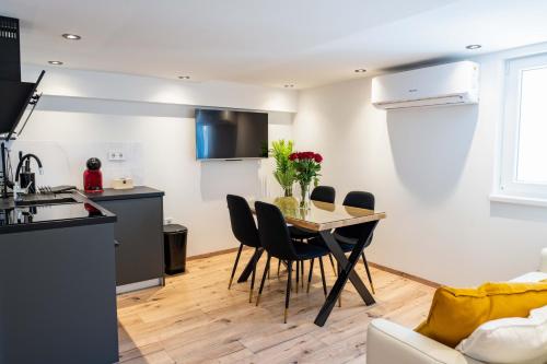 a kitchen and living room with a table and chairs at Music Apartment By Locap Group in Piran