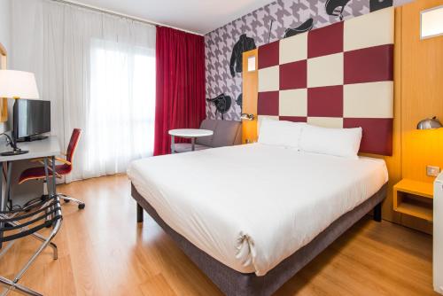 a hotel room with a large bed and a desk at ibis Styles Haydock in Haydock