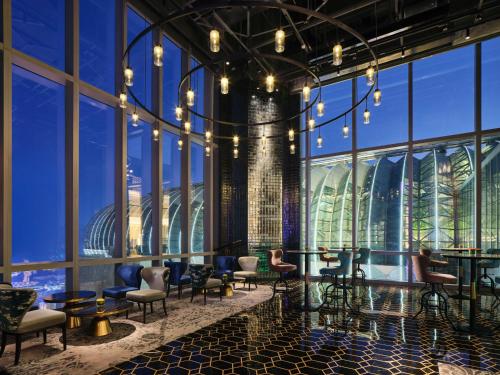 a lobby with chairs and tables and windows at InterContinental Chongqing Raffles City by IHG in Chongqing