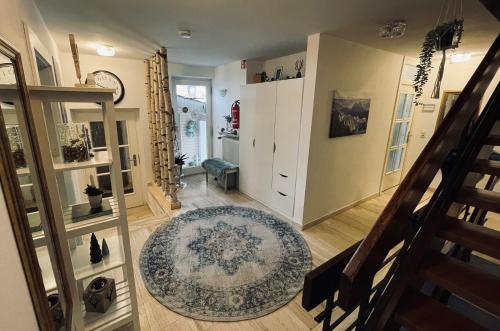 a living room with a staircase and a rug at Ferienwohnungen Germania in Schönau am Königssee